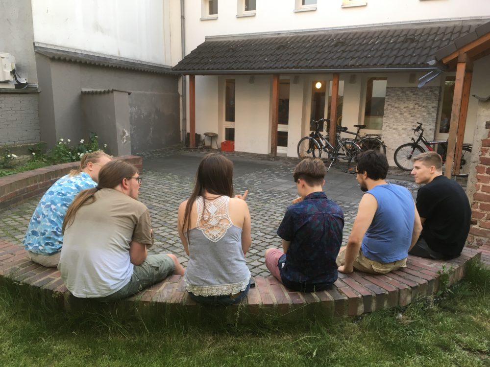Jugendliche auf der Mauer vor dem Jugendhaus