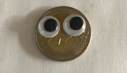 Euro-Münze mit aufgeklebten Augen